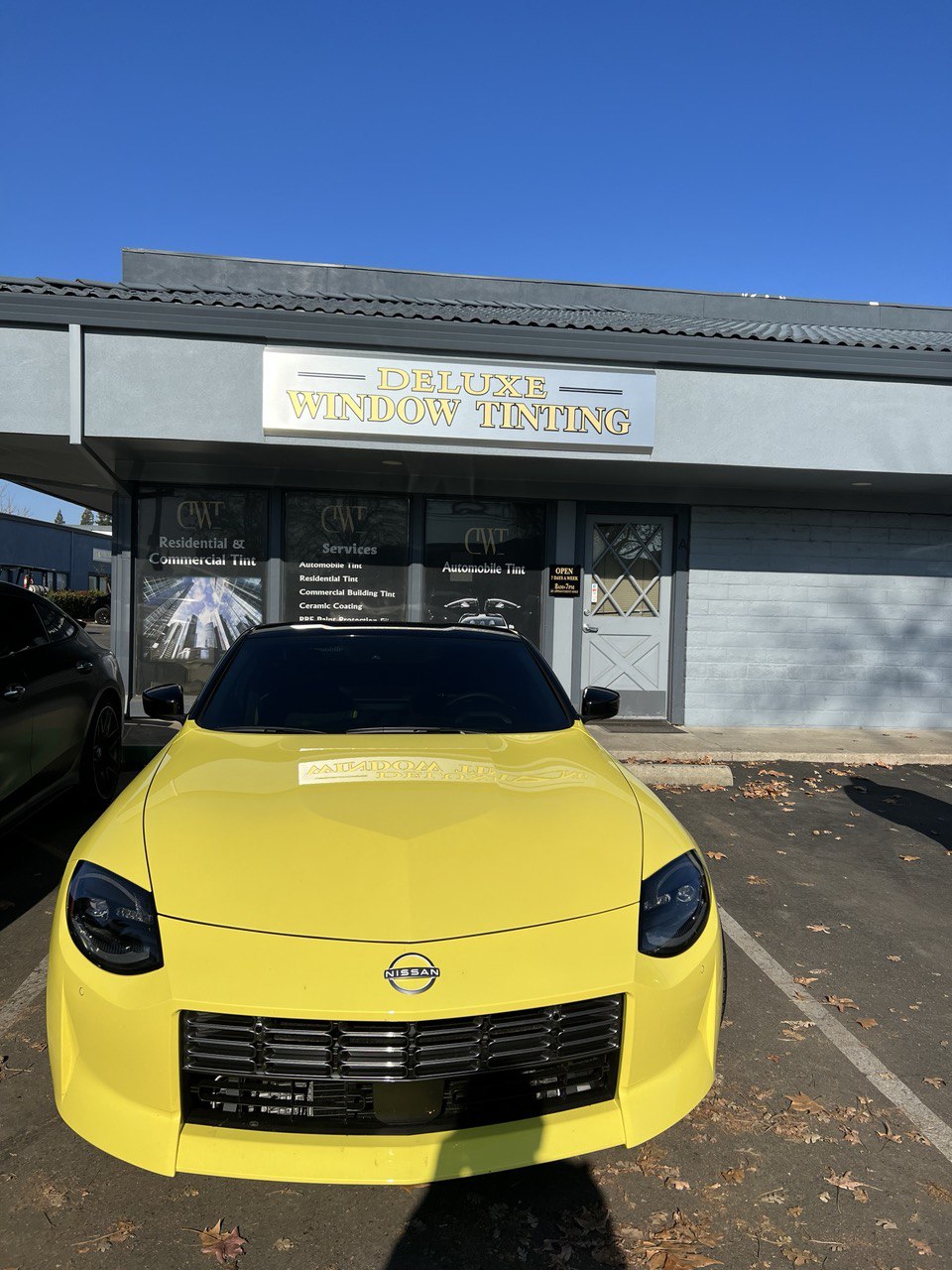 Yellow Nissan Z with professional window tinting parked in front of Deluxe Window Tinting in Gold River.