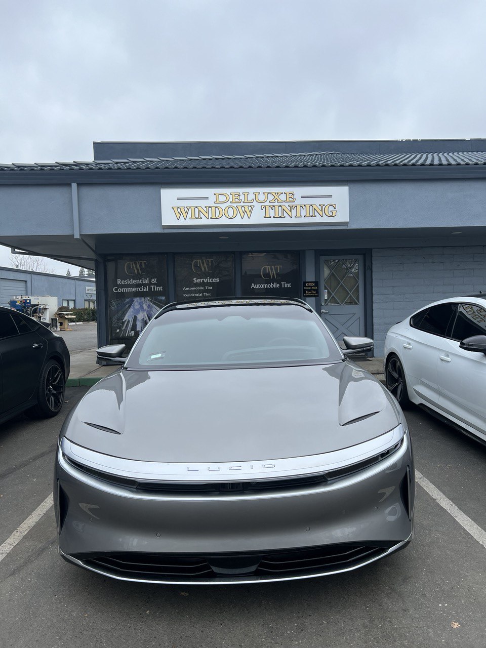 Grey Lucid Air parked outside Deluxe Window Tinting shop in Gold River, CA.
